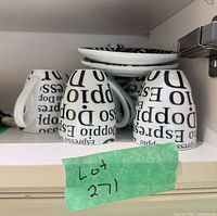 Multiple upside-down mugs and stacked saucers showing pattern