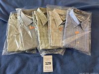 Five shirts bagged on blanket