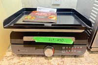 Front view showing grill and griddle tray on base