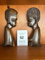 Front view of both wooden busts side by side