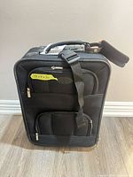 Front view showing overall suitcase, exterior pockets and wheels