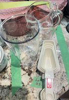 Pyrex cup, plastic beaker, nested plastic measuring cups