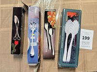 Four boxed silver plated utensils laid out