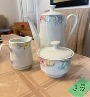 Teapot, creamer, sugar bowl with lids showing floral pattern