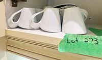 Four of the white New Wave mugs stored on shelf
