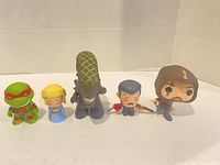 Front view of all five vinyl figurines standing in a row