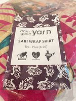 Front of packaged sari wrap skirt showing brand label and fabric colors