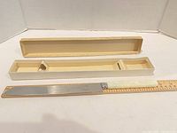 Knife with box open, ruler showing length