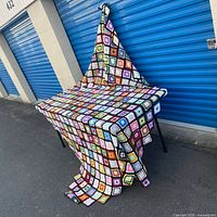 Full view of crochet blanket draped over table, showing overall size and pattern