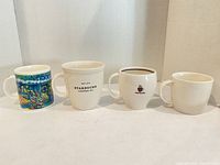 Front view of all four mugs showing different designs