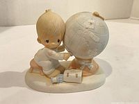 Front view showing child, globe, book, bottle