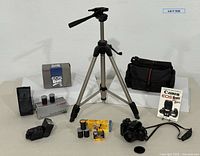 Full lot overview showing camera, lens, flash, flash box, tripod, film, bag, manual, lens cap