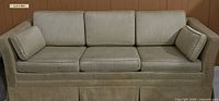Front view of beige convertible sofa with cushions and bolsters