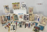 Full lot view of roughly 24 vintage sewing pattern envelopes from multiple brands