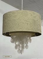 Front view of entire hanging chime showing outer shade design and capiz shells