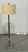 Full view of metal floor lamp with square base and drum shade