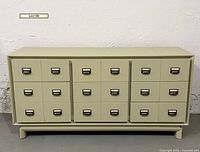 Front view of dresser showing eighteen faux card fronts and overall paint finish