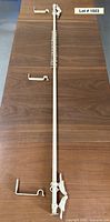 Full view of curtain rod, two bird finials, rings stacked at center, three brackets beside