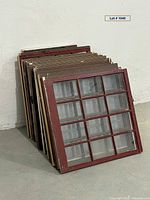 Stack of multi-pane wooden windows showing paint colors and glass intact
