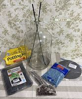Full kit showing glass carboy, potting mix, charcoal, gravel, rocks, sticks, tools, fabric circles