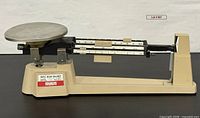 Full left side view of Ohaus triple beam balance showing beams, base and pan