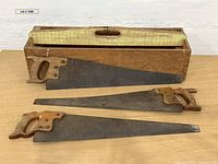 overall view of three hand saws and wooden tool box with lid