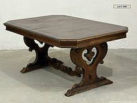 Three-quarter view of walnut trestle dining table