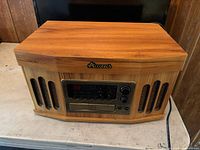 Front view of closed Accutech woodgrain console showing speaker grilles and control panel