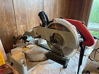 Left side view of Airco compound miter saw showing blade, fence and slide rails