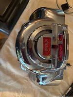 Top view of chrome jukebox showing Coca-Cola badge, coin slot, overall wear