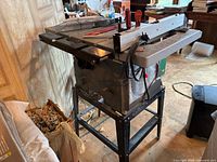 Table saw on stand with accessories visible