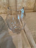 Clear rounded glass vase next to crystal bowl