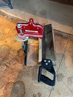 backsaw mounted in red miter guide on work surface