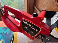 Homelite red electric chainsaw left side view showing branding and handle