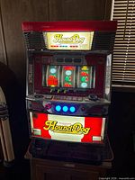 Front view of Hound Dog pachislo slot machine powered on showing illuminated marquees and reels