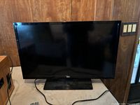 Front view of RCA flat screen TV on stand