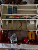 Open tackle box with trays, reels and tackle visible