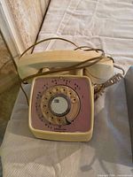 Cream rotary desk phone with handset and cord