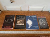 All four items laid out on tabletop: three books and one sealed portrait