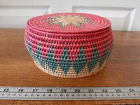 Side view of round woven basket with ruler for scale