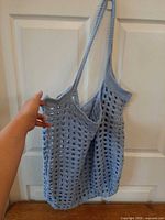 Full view of light blue crochet tote hanging on door