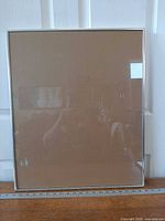 Front view of silver metal frame against door with ruler showing width