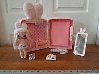 Backpack opened to show bedroom interior, doll and accessories laid out