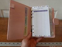 Open pink binder showing card slots, dividers and clear envelopes