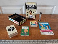 Box contents laid out: card decks, hourglass, rule sheet, box and insert