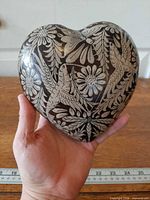 Front view of pottery heart showing bird and floral motifs
