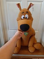 Front view of seated Scooby-Doo plush showing size against yardstick