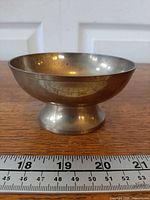 Side view of brass pedestal bowl showing profile and base