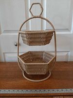 Front view of two-tier rattan organizer showing both octagonal baskets and hexagonal handle