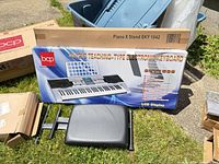 Keyboard bundle box, stand box, loose bench seat visible on lawn